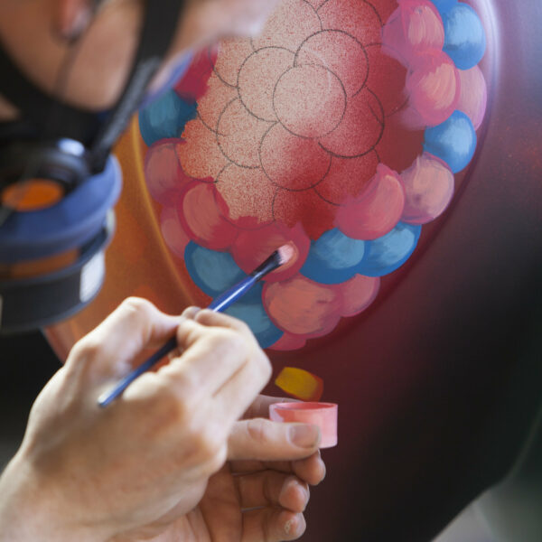arists painting a bee in the city sculpture